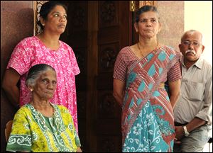Carmine Barboza, seated left, Mother-in-law of nurse at King Edward VII hospital, in London, Jacintha Saldanha, is seen with her unidentified relatives as she speaks to the media after knowing about Saldanha's death in central London, at their village house in Shirva north of Mangalore, India.