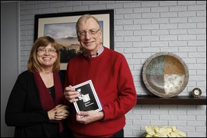 Bill and Barb McMillen pose with one of their Christmas stories that they send out as Christmas cards at their home in Perrysburg.  Bill writes the story and Barb designs the book. They print about 300 copies.