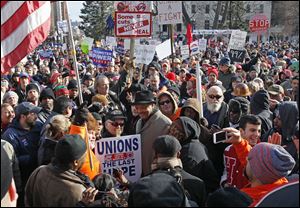 The Rev. Jesse Jackson, center, joins demonstrators protesting against right to work legislation at the Michigan State Capitol in Lansing, Michigan.