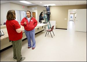 Dr. Kittsen McCumber, left, and Audrey Sharp, RVT, right, talk in the reception area of the new Animal Emergency and Critical Care Center of Toledo building while the finishing touches are done on Douglas Rd.