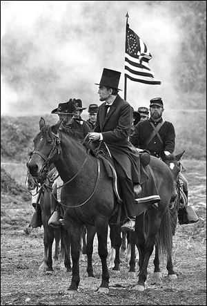 Daniel Day-Lewis, center, as President Abraham Lincoln, looks across a battlefield in the aftermath of a terrible siege in this scene from director Steven Spielberg's drama 'Lincoln.' 