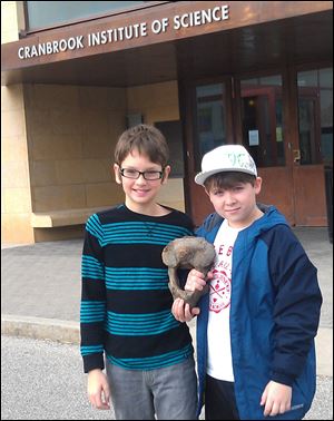 Eric Stamatin, left, and Andrew Gainariu stand outside the museum in Bloomfield Hills, Mich. Stamatin, 11, of Shelby Township, and his cousin, Andrew Gainariu, also 11, of Troy, found the mastodon bone over the summer while exploring in Eric's backyard.