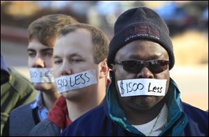 Protesters hold a silent protest in Lansing, Mich., Wednesday, a day after thousands of protesters rallied on the grounds as lawmakers pushed final versions of right-to-work legislation. The tape over their mouths demonstrates how Gov. Rick Snyder and his allies have silenced Michigans middle class, and effectively cut the wages of Michiganders by $1,500.