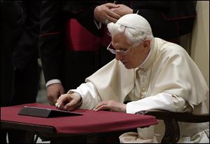 Pope Benedict XVI pushes a button on a tablet at the Vatican today.