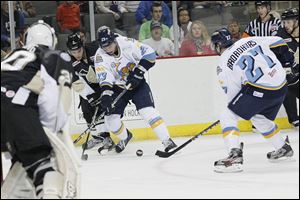 Walleye right wingman Luke Glendening, center, and left wingman Terry Broadhurst, right, fight for control of the puck during the first period against the Wheeling Nailers at the Huntington Center in Toledo.