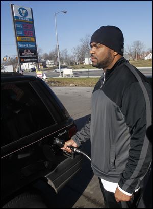Toledoan Ernest Banks fills up at a Valero station on Monroe St. where the cash price for regular is $2.989. Mr. Banks said he was surprised to see prices dip as Christmas approaches. AAA Northwest Ohio reported Toledo stations averaged $3.26 a gallon early Wednesday morning, although some stations in the region could be found selling fuel for less than $3 a gallon.