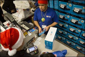 A customer makes a purchase in the Times Square Toys-R-Us store in New York. U.S. retail sales rose 0.3 percent in November from October, the Commerce Department said Thursday. That offset a 0.3 percent decline in October from September. 