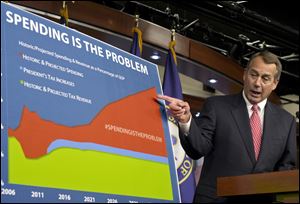 House Speaker John Boehner points to a chart to emphasize his talking point that government spending complicates the negotiations on avoiding the so-called 