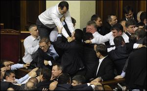 Ukrainian lawmakers fight around the rostrum during the first session of Ukraine's newly elected parliament in Kiev, Ukraine.