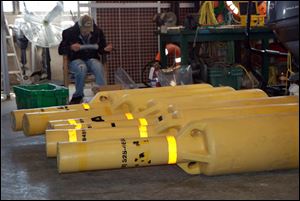 Scientific buoys that were placed on Lake Erie lie on the floor of a storage unit. The buoys are used to record temperature data of the lake. Three are missing, and the officials are asking for help to recover them.