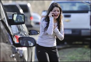 A woman waits to hear about her sister, a teacher, following a shooting at the Sandy Hook Elementary School in Newtown, Conn.