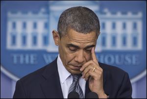 President Barack Obama wipes his eye as he talks about the Connecticut elementary school shooting in the White House briefing room in Washington.