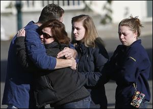 Mourners embrace outside Saint Rose of Lima Roman Catholic Church on Saturday.