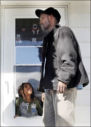 His granddaughter C'Asia Stewart listens as Darrell Russell talks about his nephew, Lamine J. Wilson, who was shot and killed in East Toledo.