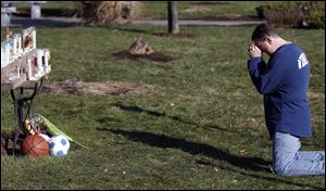 A man weeps in front of a memorial for shooting victims outside Saint Rose of Lima Roman Catholic Church in Newtown, Conn. Friday’s massacre of children and adults at Sandy Hook Elementary School elicited horror and soul-searching around the world, and the town grappled Saturday with the aftermath.