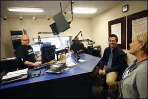 Rob Kelly, left, a DJ of 20 years at YES-FM, listens as Janet Yonke, the underwriting manager, catches up with Steve Mohr, a former DJ, in the YES-FM studio. The Christian radio station started a new program Dec. 3 that urges teens to rebel by following God.