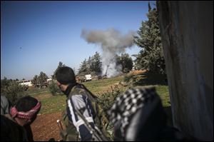 Free Syrian Army fighters react after an explosion during heavy clashes with government forces at a military academy besieged by the rebels north of Aleppo, Syria, Saturday.