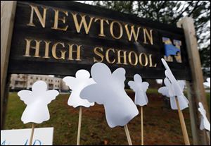 Angel cut-outs are displayed outside Newtown High School in Newtown, Conn. today. A gunman opened fire at Sandy Hook Elementary School in the town, killing 26 people, including 20 children before killing himself on Friday.