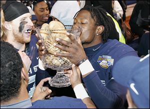 Utah State's Nevin Lawson celebrates by kissing the Famous Idaho Potato Bowl trophy after defeating the University of Toledo. The Rockets were stymied mainly by the Aggies' defense.