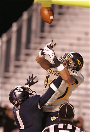 Toledo's Justin Olack, top, tries to pull down a reception against Utah State's Nevin Lawson.