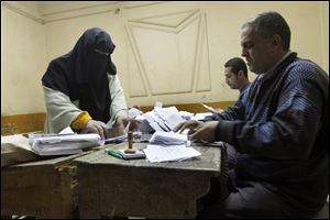 Egyptian referendum officials count votes at a polling station in Cairo, Egypt, late Saturday.