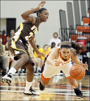 The Falcons' Jillian Halfhill dives for the ball before the  Cowgirl's Chelan Landry gets there during the second half of women's basketball action at the Stroh Center on Saturday on campus..