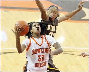 BGSU's Alexis Rogers takes the ball to the hoop past Wyoming's Chaundra Sewell during the first half of women's basketball action at the Stroh Center on Saturday. The Falcons won 79-69.