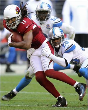 Arizona Cardinals wide receiver Larry Fitzgerald (11) is tackled by Detroit Lions cornerback Chris Houston (23) during the second half of their game in Arizona. The Cardinals won 38-10.