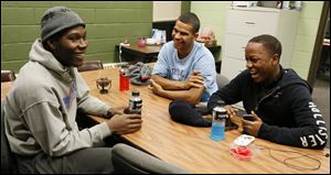James Evans, 20, left, Derrick Ward, 19, center, and Timothy Harris,17, joke around at the Frederick Douglass Community Center in central Toledo. The trio enjoy playing basketball at the center.