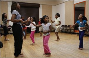 Jayla Satterfield, 17, teaches Nacheyl Geer, 8, center, and other youngsters ethnic dance at the community center.