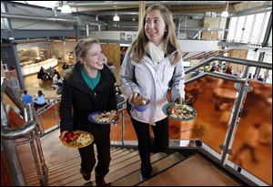 Shannon Cassidy, left, and Amber Herron, both 19-year-old freshmen at BGSU, carry their food to a table at the Oaks dining hall. It and Carillon Place lack the cafeteria trays traditionally found in dining halls.