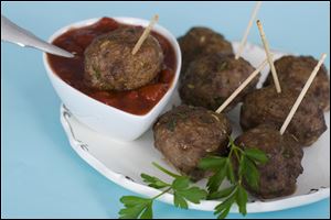 Cocktail meatballs with cranberry marinara are shown served on a platter.
