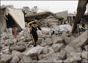 A boy walks in rubble at the scene of a car bomb attack in al-Mouafaqiyah, a village inhabited by families from the Shabak ethnic group, near the city of Mosul, 225 miles northwest of Baghdad, Iraq.
