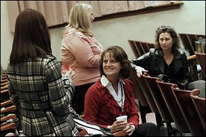 Kelly Sell, left, and Lisa Richard, center, join other members in chatting before the Downtown Perrysburg Inc. annual general membership meeting at the Auditorium of the Perrysburg Schools Board of Education building in Perrysburg. The group met to review 2012 accomplishments and preview 2013 plans.