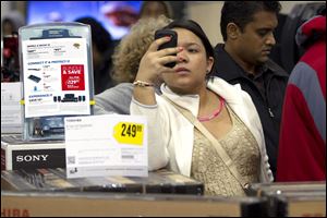 A shopper at a Florida Best Buy checks her smart phone. More retailers are plumbing social media sites such as Facebook to learn what their customers want to see on store shelves.