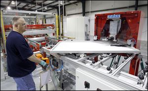 Kevin Morris crimps the corners of a 250-watt solar panel frame at Isofoton North America Inc. in Napoleon. The factory in the Henry County seat has plans to add employees.