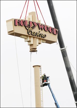 CTY  sign20p  Workers from the Toledo Sign Co. install a new sign in front of the Hollywood Casino in Toledo, Wednesday, December 19, 2012.  THE BLADE/DAVE ZAPOTOSKY