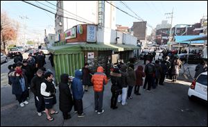 South Koreans wait in line to cast their votes for a presidential election at a polling station in Seoul, South Korea, today.