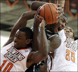 Bowling Green State's Craig Sealey, left, and forward Cameron Black, right, battle Michigan State guard Branden Dawson for a rebound Tuesday night. Bowling Green lost 64-53.