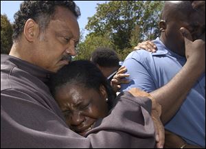 The Rev. Jesse Jackson comforts relatives of crash victim Terrance Shurn, whose death sparked rioting. Alma White, center, is Mr. Shurn’s aunt, and Shannon Shurn is his brother.