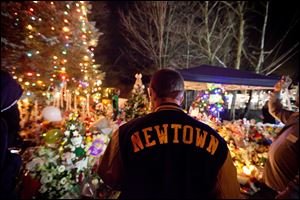 Greg Frattaroli, 19, of Newtown, Conn., visits a memorial for the Sandy Hook Elementary School shooting victims earlier this week.