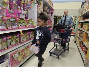 Lauran Coats, 9, shopping with TPD officer Adam Eilerts. Both Lauren and her brother Michael, 8 [not pictured], bought gifts for other members of their family.