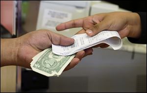 A cashier hands a customer his change and receipt during a transaction at a Sears store, in Henderson, Nev. 