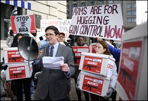 Josh Nelson, campaign manager, CREDO Mobile, center, speaks after his group was denied entrance to the Williard InterContinental Hotel where they wanted to deliver a petition to the National Rifle Association calling for the NRA to get out of the way of gun control, as the NRA is having a news conference in Washington.