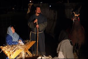 Kelly and Kyle Tarry portray Mary and Joseph in a live version of the Nativity during the fifth annual Christmas tree lighting ceremony at Strawberry Acre Park in Holland, Ohio. Area ministers, like their parishioners, spend time on Christmas with family members.