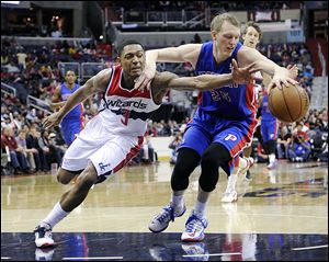 The Wizards' Bradley Beal (3) reaches for the ball, but is held back by the Pistons' Kyle Singler during the second half on Saturday.