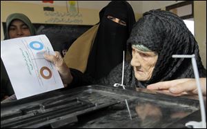 Amnah Sayyed Moussa, 85, casts her vote for the second round of a referendum on a disputed constitution drafted by Islamist supporters of President Mohammed Morsi in Giza, Egypt.