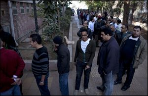 Egyptians queue to vote outside a gymnasium hall that is used as a polling station during the second round of a referendum on a disputed constitution drafted by Islamist supporters of president Mohammed Morsi, in Giza, Egypt, Saturday, Dec. 22, 2012. (AP Photo/Nasser Nasser)