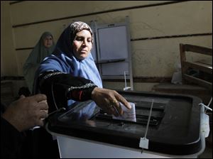 An Egyptian woman casts her vote for the second round of a referendum on a disputed constitution drafted by Islamist supporters of President Mohammed Morsi in Giza, Egypt, Saturday, Dec. 22, 2012. (AP Photo/Amr Nabil)