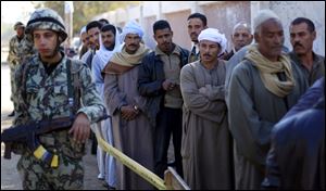 Egyptians line up outside a polling station wait their turn to cast their votes during the second round of a referendum on a disputed constitution drafted by Islamist supporters of President Mohammed Morsi in Fayoum, about 100 kilometers (62 miles) south of Cairo, Egypt, Saturday, Dec. 22, 2012.(AP Photo/Khalil Hamra)